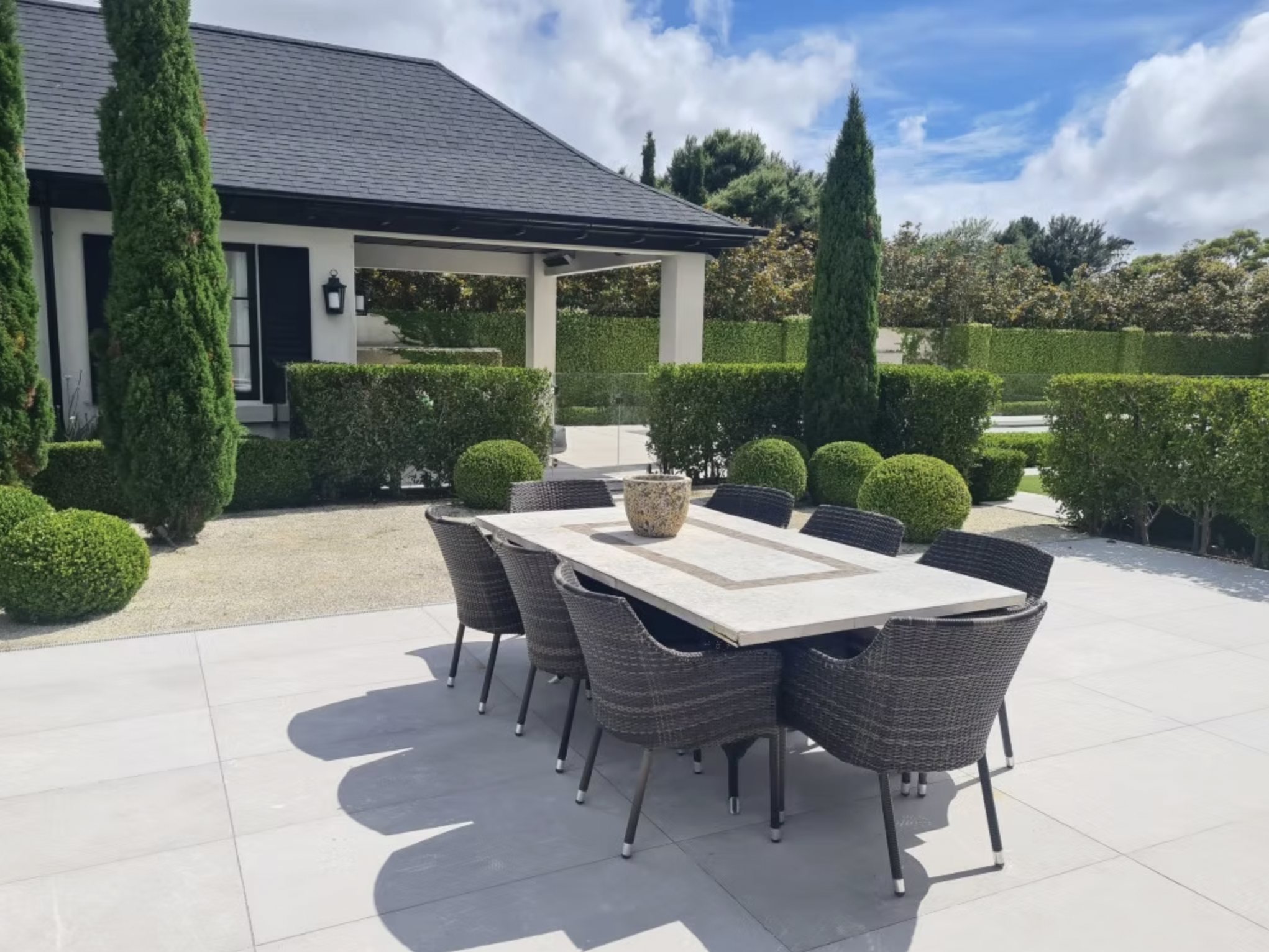 Formal courtyard with outdoor dining and clipped hedging